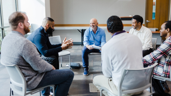 A group or men sitting in a circle.